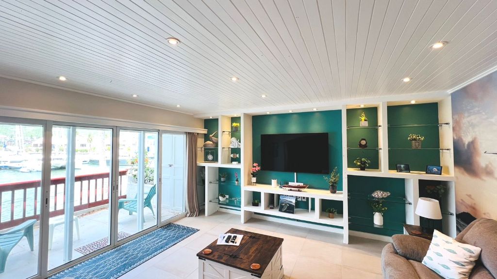 Living room with teal media wall and sliding doors to the lagoon-view balcony